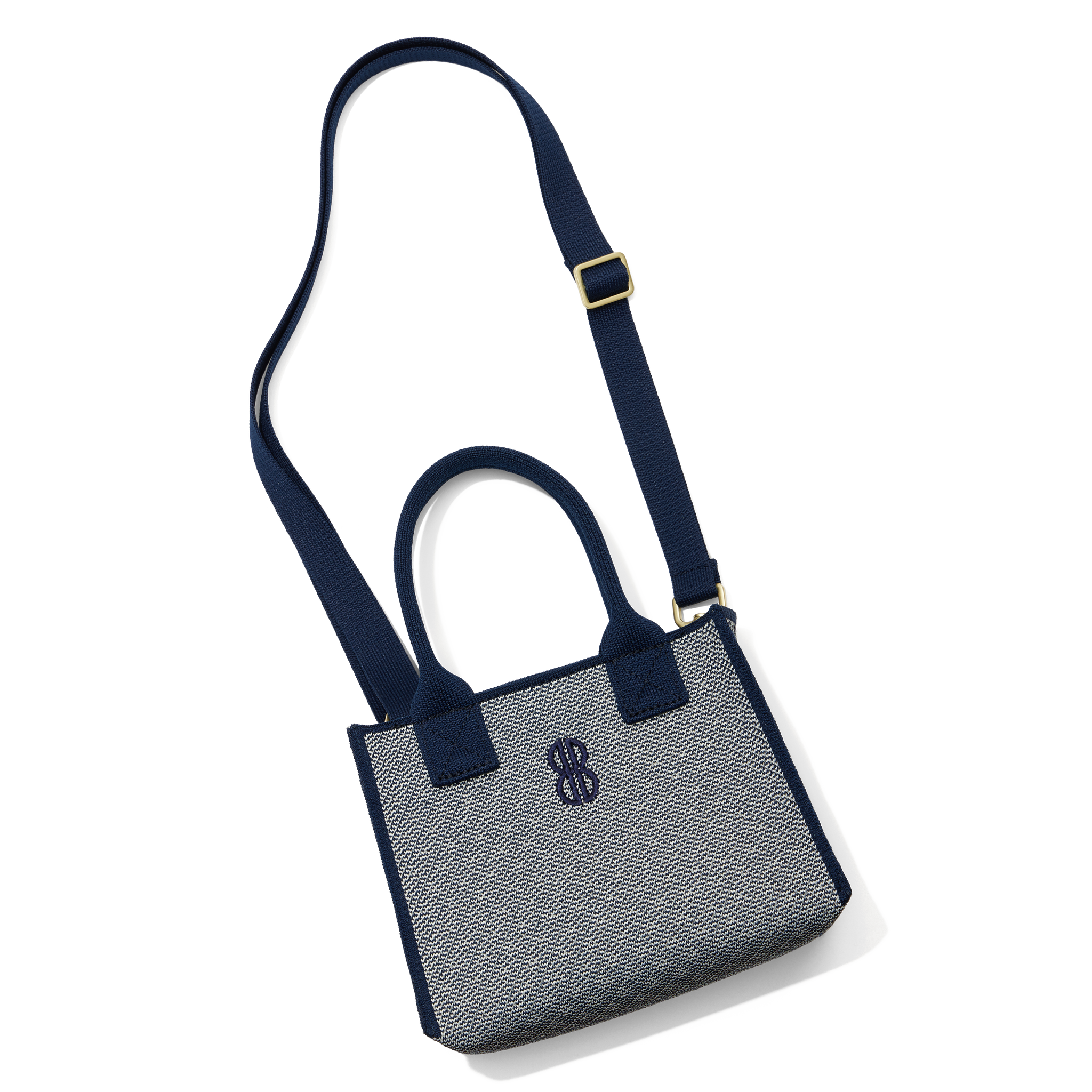 Madison Mini Handbag lying on the floor with a shoulder strap attached