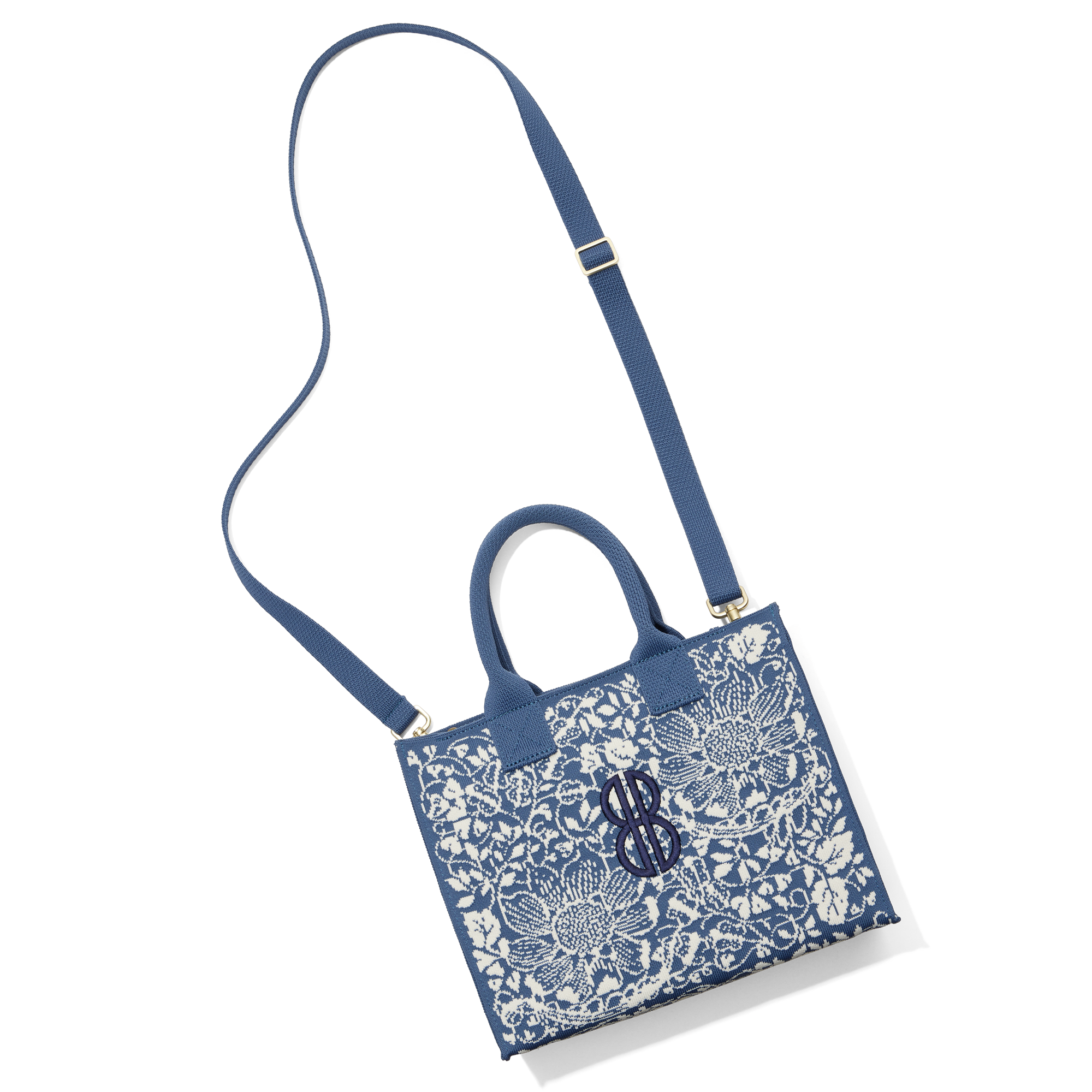 Madison Small Handbag lying on the floor with a shoulder strap attached